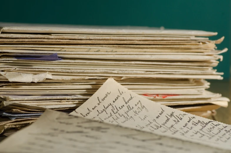 a stack of papers sitting on top of a table, a portrait, flickr, letterism, museum archive, writing in journal, closeup photo, photograph credit: ap