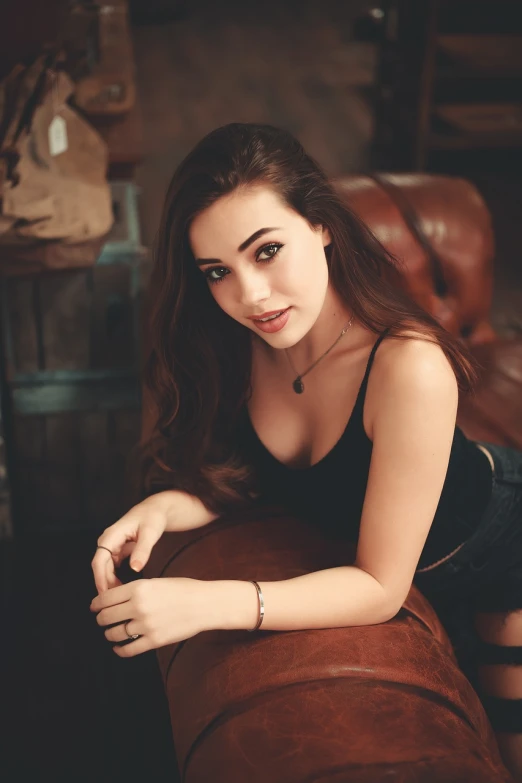 a beautiful young woman sitting on top of a brown couch, reddit, tachisme, portrait sophie mudd, arab young monica belluci, headshot profile picture, amouranth