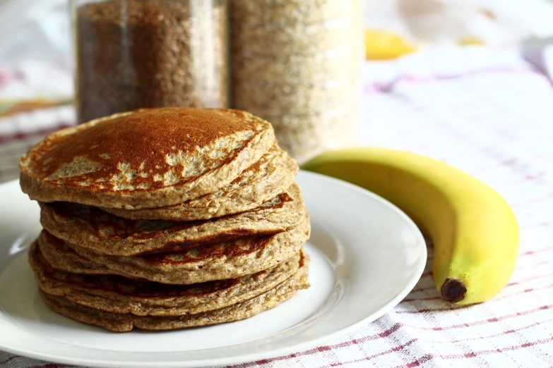 a stack of pancakes sitting on top of a white plate, a portrait, shutterstock, mineral grains, banana, highly detailed photo, flax