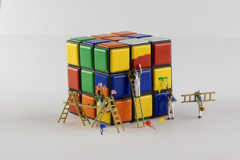 a group of people standing on top of a rubik cube, a pop art painting, cubo-futurism, repairing the other one, diorama macro photography, ladders, toy photo