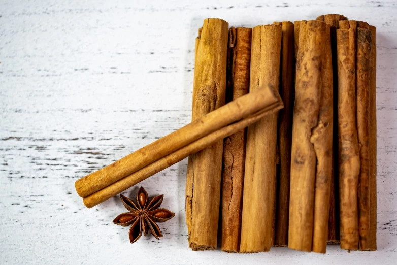 cinnamon sticks, anise, and star anise on a white table, a stock photo, antipodeans, 🎀 🗡 🍓 🧚, exquisite and smooth detail, wood materials, simple but effective composition