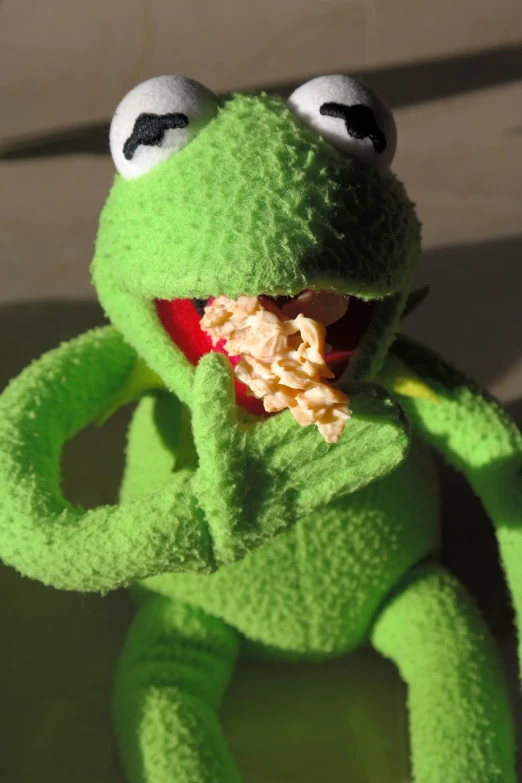 a close up of a stuffed animal with food in it's mouth, a picture, inspired by Leo Leuppi, reddit, kermit, british stopmotion, unedited, luscious with sesame seeds