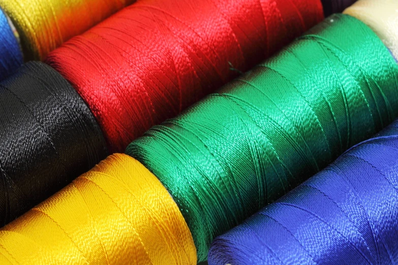 a close up of a bunch of spools of thread, a stock photo, flickr, primary colours, ralph horsley vivid color, silk tarps hanging, night setting