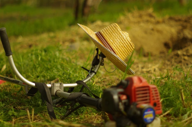 a straw hat sitting on the handle of a lawn mower, a tilt shift photo, by Romain brook, flickr, realism, cycle render, crashed in the ground, redneck engineering, view from the side”