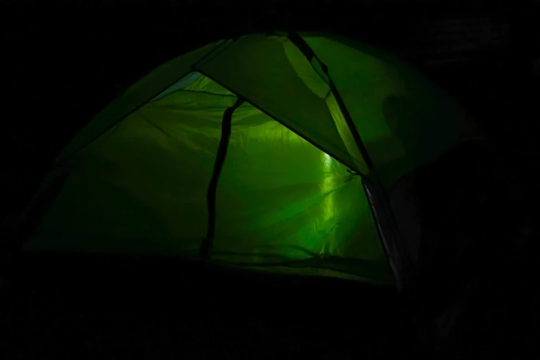 a green tent lit up in the dark, light and space, luminescence, moonrays, up close picture, slimy and reflective