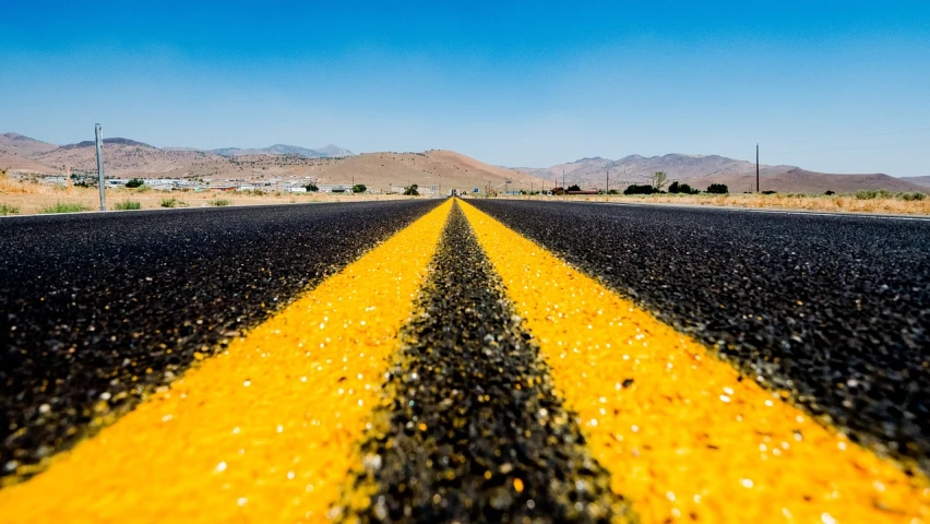 a yellow line in the middle of a road, a tilt shift photo, by Dave Melvin, shutterstock, road california desert, vibrant high contrast, runway photo, take off