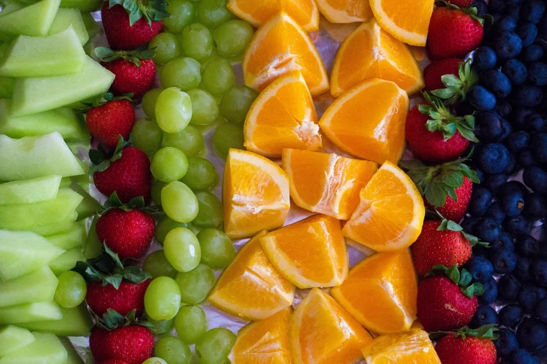a close up of a plate of fruit with oranges and grapes, process art, green bright red, in a row, high res photo, snacks