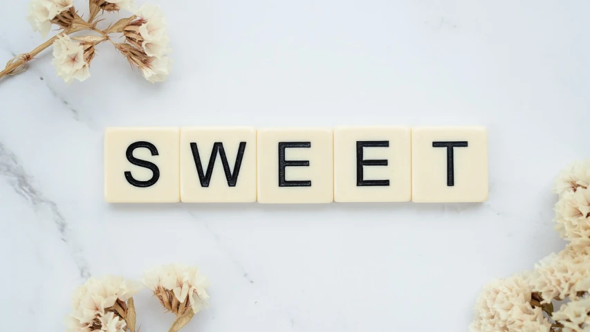 the word sweet spelled in scrabbles on a marble surface, pexels, 😃😀😄☺🙃😉😗, on a pale background, background image, candy decorations