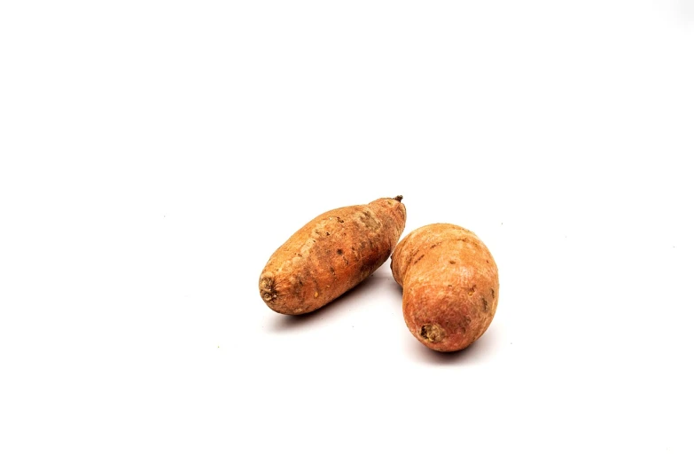 two sweet potatoes sitting next to each other on a white surface, a stock photo, renaissance, raw dual pixel, jajaboonords flipjimtots, malaysian, cinematic very crisp