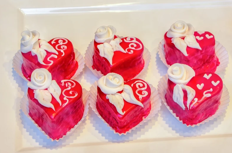 a number of heart shaped cakes on a plate, a photo, inspired by Rudolf von Alt, art nouveau, closeup photo, crimson and white color scheme, california;, high res photo