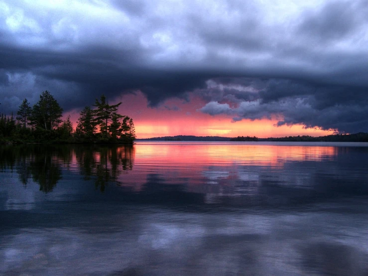 a large body of water under a cloudy sky, a picture, by Andrew Domachowski, flickr, romanticism, dramatic storm sunset, finland, deep colours. ”