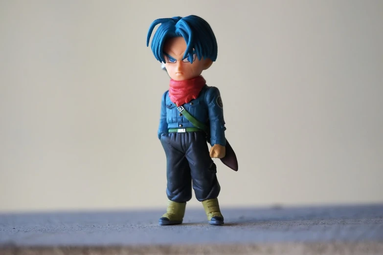 a close up of a toy figure on a table, a character portrait, by Hiroyuki Tajima, pexels, dragon ball super, dressed in blue, wearing a dark shirt and jeans, chibi style