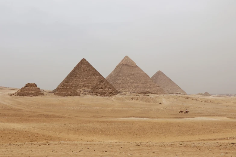 a group of three pyramids in the desert, egyptian art, pexels, plein air, misty, photo taken in 2018, slight overcast weather, shai-hulud