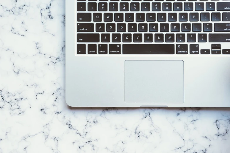 a laptop computer sitting on top of a marble table, by Carey Morris, pexels, viewed from above, keyboard, background image, nongraphic