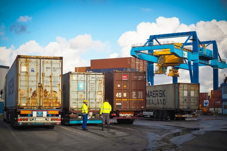 a man standing next to a truck in a parking lot, by Zahari Zograf, pexels, container ship, sweden, cranes, inspect in inventory image