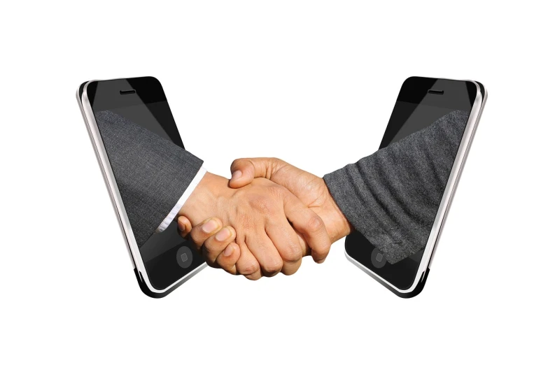 two men shaking hands in front of a laptop, a photo, realism, android phones, stacked image, iphone photo, istockphoto