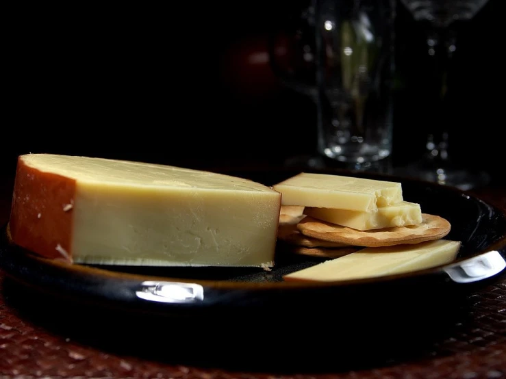 a plate of cheese and crackers on a table, a portrait, by Samuel Birmann, pexels, dau-al-set, with a black dark background, long snout, shiny crisp finish, a pale skin