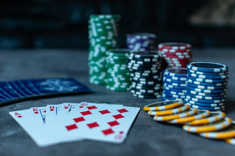 a table topped with poker chips and playing cards, by Adam Marczyński, shutterstock, 🦩🪐🐞👩🏻🦳, bulgari, blue colored, close up image