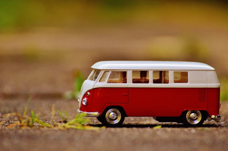 a toy bus is sitting on the ground, pixabay contest winner, minimalism, vertical wallpaper, vw microbus driving, crimson and ecru color scheme, smooth tiny details