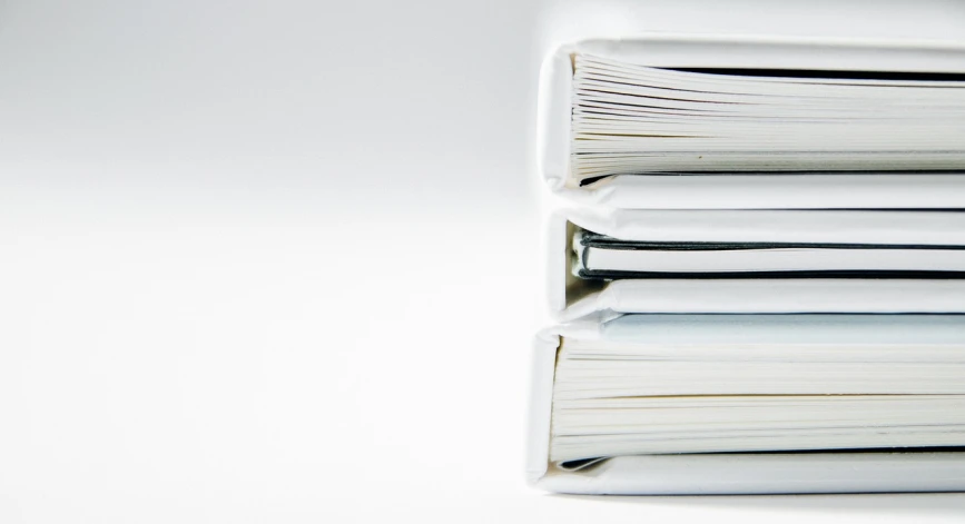 a stack of books sitting on top of a table, by Shigeru Aoki, clean white paper background, technical document, complaints, portfolio