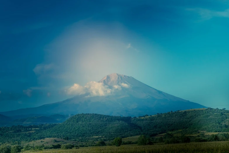 a view of a mountain with a cloud in the sky, a tilt shift photo, fuji lut, the photo was taken from afar, beksinsky, genzoman