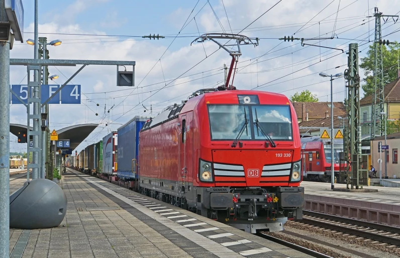 a red train pulling into a train station, by Werner Gutzeit, flickr, truck, electric, 6 4 0, hsv