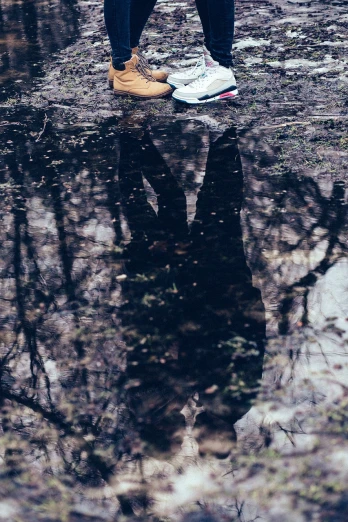 a person standing on top of a puddle of water, a picture, by Elsa Bleda, surrealism, lying on the woods path, sneaker photo, water mirrored water, miro petrov
