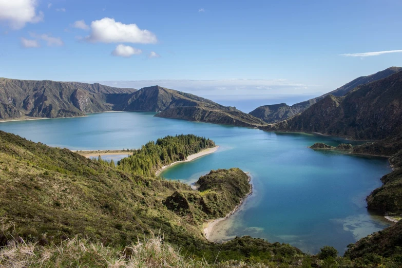 a large body of water sitting on top of a lush green hillside, by Carlo Martini, shutterstock, crater lake, salvador, 1128x191 resolution, volcanic landscape