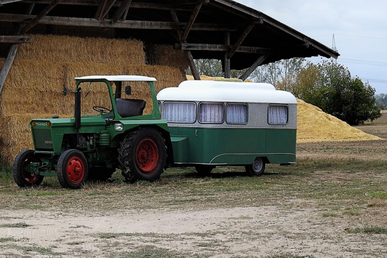 a green tractor parked next to a pile of hay, by Hans Schwarz, pixabay, folk art, next to an rv, 1 9 5 0 s scrambler, with a roof rack, traveling in france