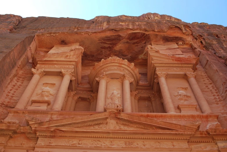 a large building built into the side of a mountain, flickr, art nouveau, ancient persian temple dungeon, middle close up shot, jordan, pillars on ceiling