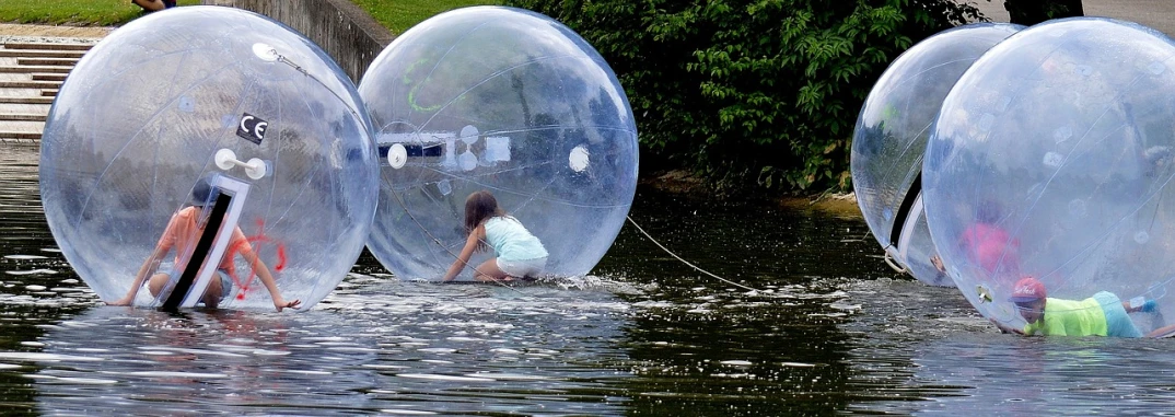 a group of people floating in a body of water, a picture, pixabay, interactive art, bubble chamber, inflatable, she is walking on a river, teenage girl