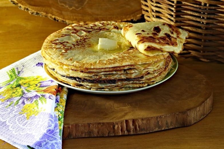 a stack of pancakes sitting on top of a wooden cutting board, a portrait, pixabay, dau-al-set, traditional russia, butter, very very very beautiful!, ethiopian