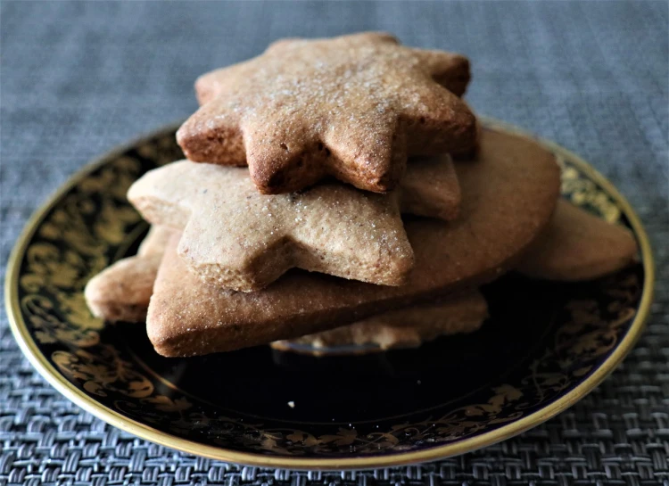 a close up of a plate of cookies on a table, by Sylvia Wishart, stars, symmetrical shape, stacked, sandy