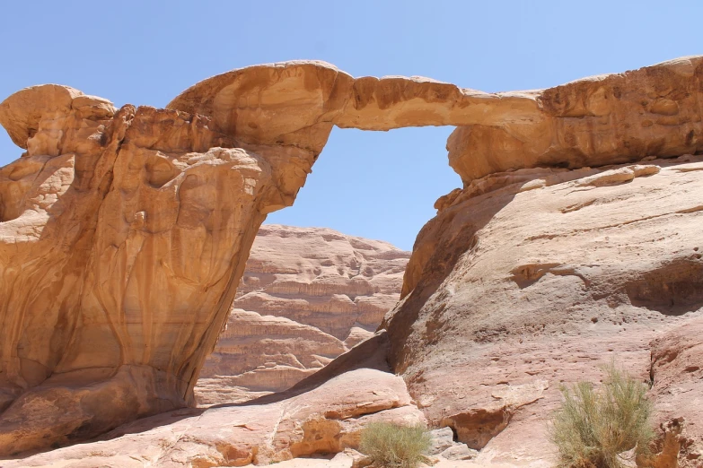 a large rock formation in the middle of a desert, stone bridge, halfrear, reddish, window open