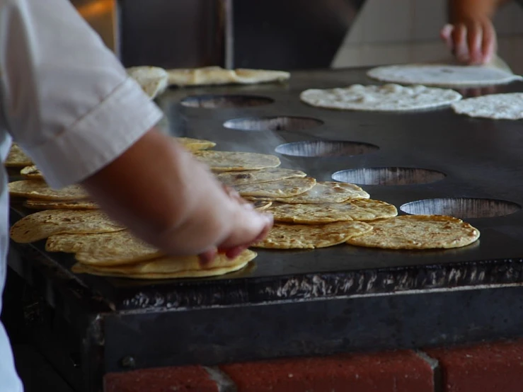 a close up of a person making tortillas on a grill, a picture, by Amelia Peláez, pexels, dau-al-set, panels, bakery, many small details, pancakes