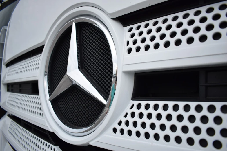 a close up of a mercedes logo on a vehicle, by Thomas Bock, shutterstock, photorealism, truck, white muzzle and underside, stock photo, low angle photo