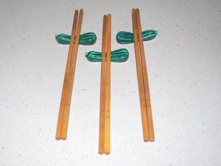 a group of chopsticks sitting on top of a table, ebay, that has the form of a dragonfly, symmetrical front view, plastic