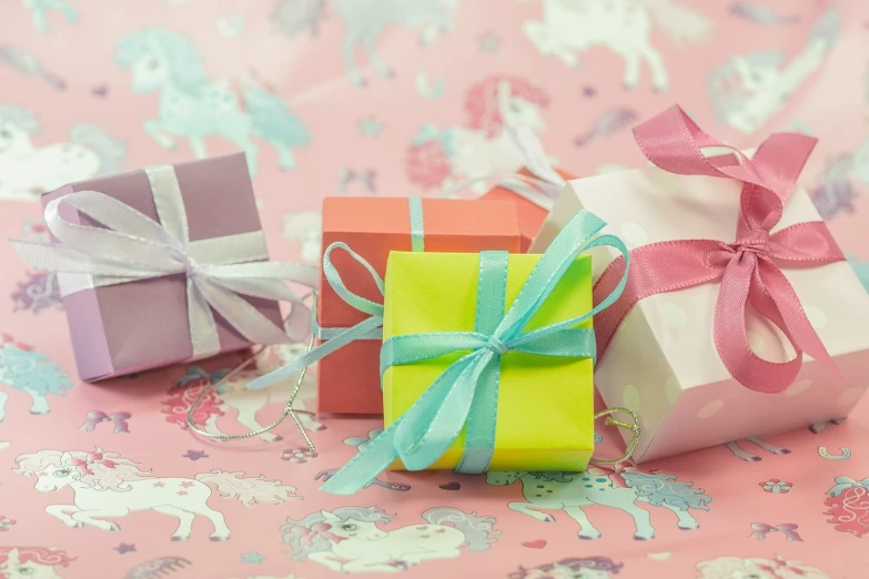 a couple of small gift boxes sitting on top of a table, by Rhea Carmi, pixabay, unicorns, pastel makeup, ribbon, 3 5 mm photo