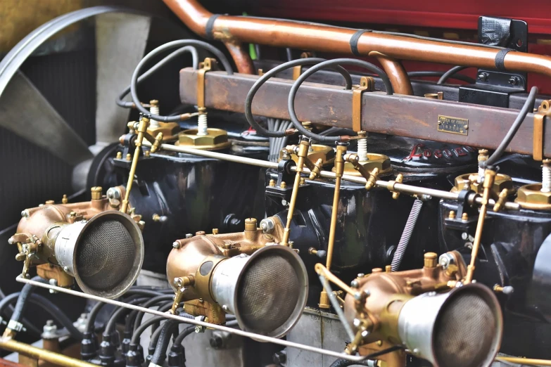 a close up of a engine on a train, by David Simpson, flickr, art nouveau, vintage aston martin, hoses:10, golden engines, 4 k detail