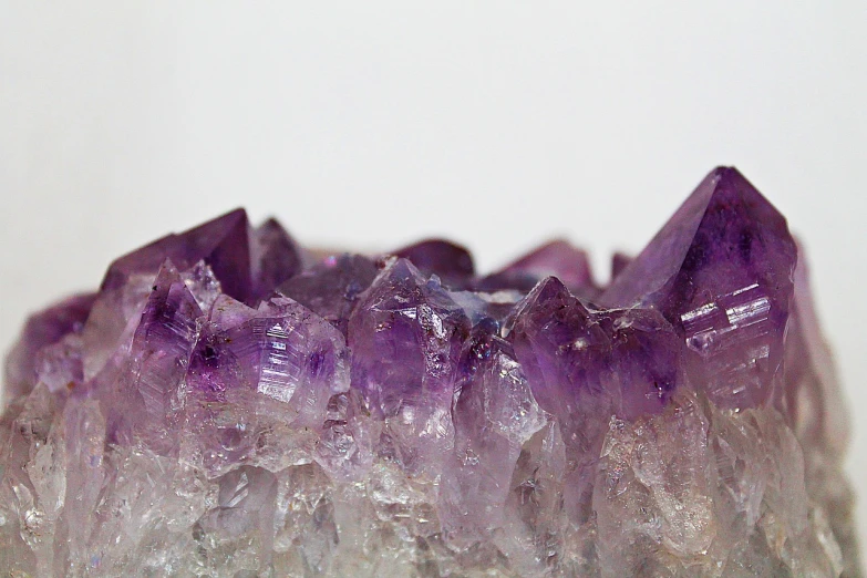 a cluster of purple crystals sitting on top of a table, a macro photograph, anthropology photo”, neck zoomed in, sam weber, beginner