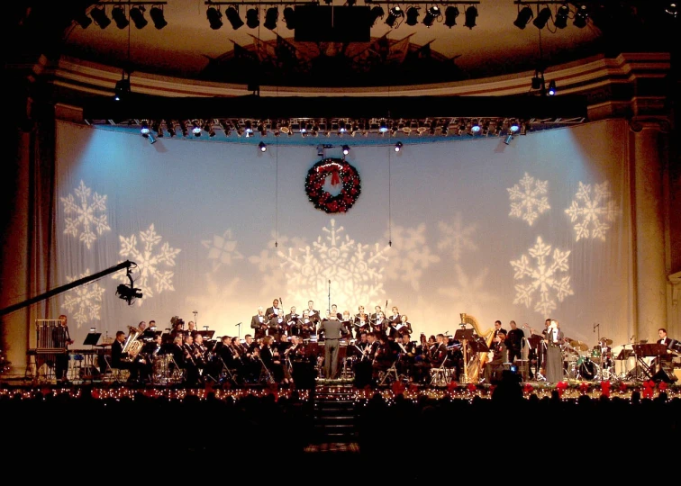 a group of people standing on top of a stage, by Susan Heidi, flickr, christmas, orchestra, 2 0 0 2 photo, photo of a beautiful