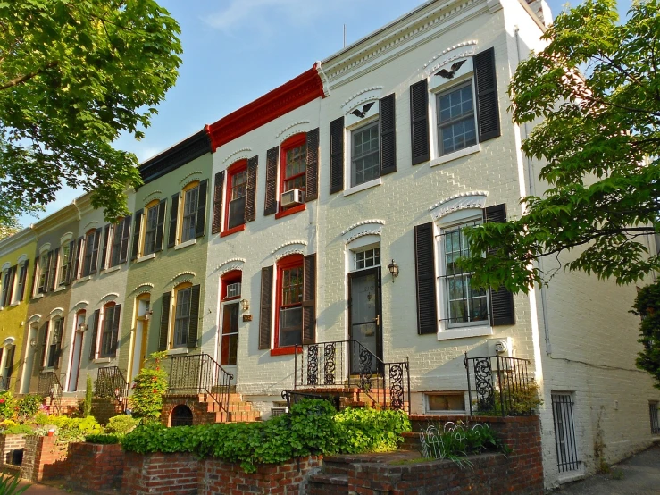 a row of houses on a city street, a photo, by Randy Post, shutterstock, washington dc, beautifully painted, tall terrace, great details