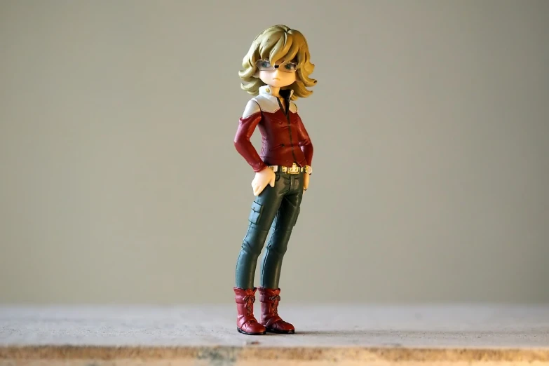 a close up of a figurine of a woman, a picture, inspired by Yumihiko Amano, red shirt brown pants, short curly blonde haired girl, full body character concept, ( ( ( wearing jeans ) ) )