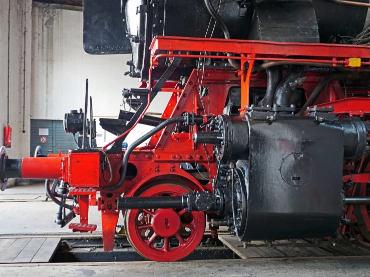 a close up of a red and black train engine, shutterstock, bauhaus, cart wheels, heavy under paint, interior, looking from side and bottom!