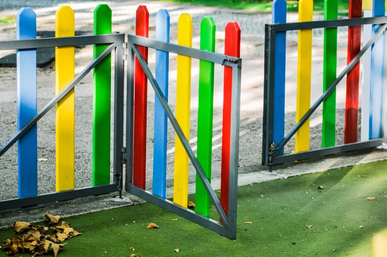 a yellow fire hydrant sitting next to a colorful fence, shutterstock, color field, standing astride a gate, activity play centre, panels, green blue red colors