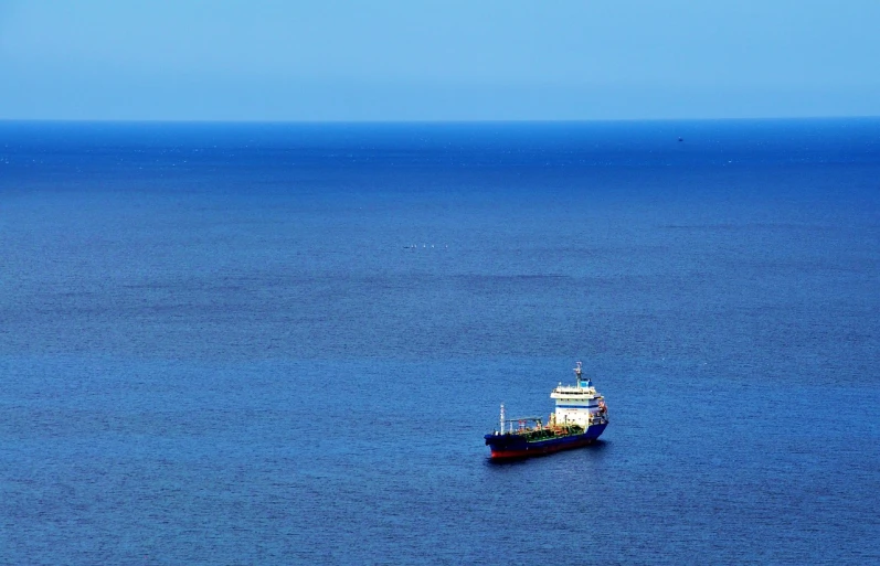 a large boat in the middle of a large body of water, a photo, by Richard Carline, black sea, blue, telephoto long distance shot, highfleet