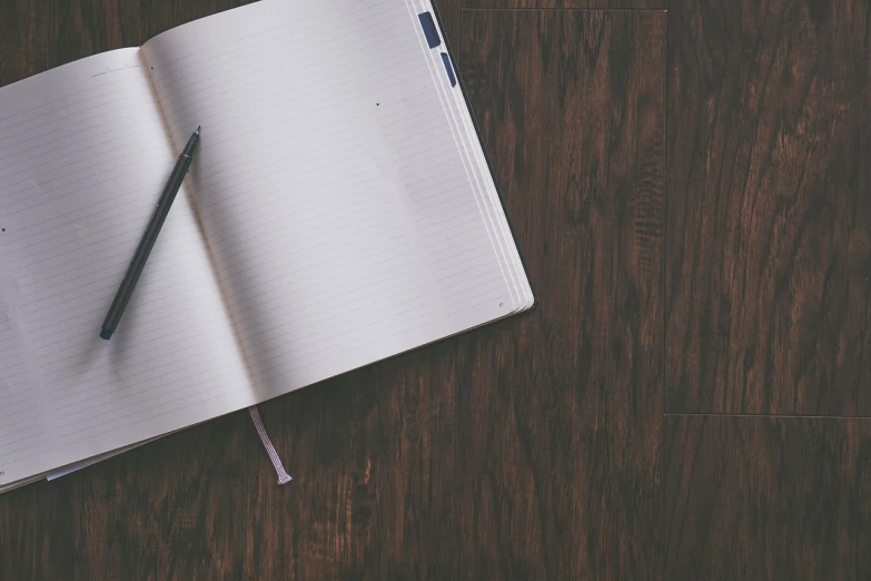 an open notebook with a pen on top of it, pexels, on an empty stage from above, high res photo, full length photo, background image