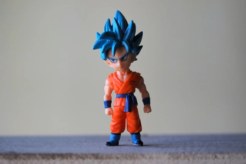 a close up of a toy figure on a table, inspired by Toriyama Sekien, pexels, super saiyan blue, blue and orange, miniature product photo, looking the camera