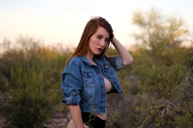 a woman in a denim jacket posing for a picture, by Dan Luvisi, tumblr, realism, amouranth, in nature, tight attire, desertpunk