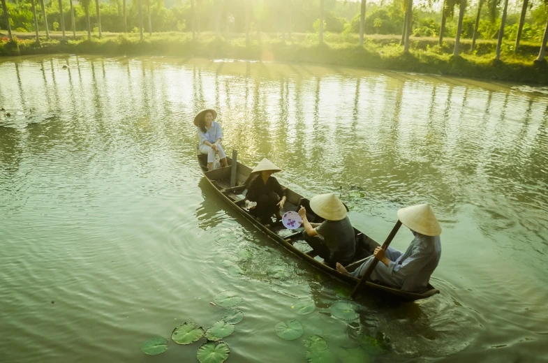 a couple of people riding on top of a boat, a picture, by John La Gatta, shutterstock, ao dai, in a pond, stock photo, sunlit